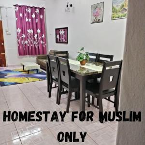 jadalnia ze stołem i krzesłami w obiekcie Rizki Homestay w mieście Nibung Tebal