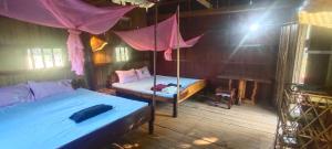 1 dormitorio con 2 camas y un columpio en Tree Trails Homestay & Offers Jungle Trekk-Scooter For Rental en Banlung