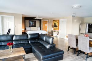 a living room with a black leather couch and a bed at Albert's in Shelburne