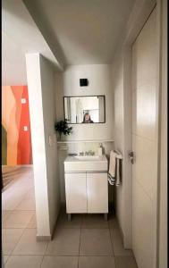 uma casa de banho com um lavatório branco e um espelho. em Hermoso Departamento en Ciudad de Mendoza em Mendoza