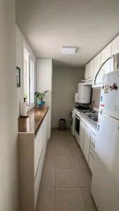 uma cozinha com armários brancos e um frigorífico branco em Hermoso Departamento en Ciudad de Mendoza em Mendoza