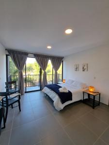 1 dormitorio con 1 cama grande y balcón en Guatapé Country House Hotel en Guatapé