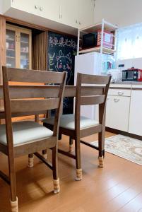 a kitchen with two wooden chairs and a table at ヴィラ 奈良 with gift 小さなギフト付 奈良駅から15から20分 in Nara