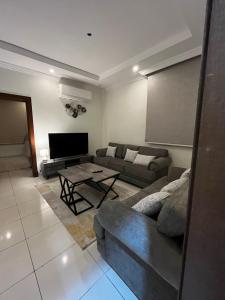 uma sala de estar com um sofá e uma mesa em شقة بغرفتين نوم وصالة بالمحمدية em Abḩur al Janūbīyah