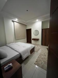 Un dormitorio con una cama grande y una ventana en شقة بغرفتين نوم وصالة بالمحمدية en Abḩur al Janūbīyah