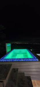 Villa Colinas Del Cielo في San Cristóbal: حمام سباحة في الليل مع أضواء زرقاء