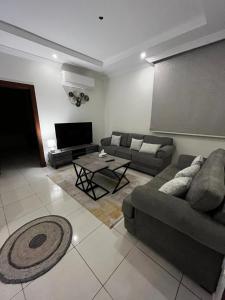 sala de estar con sofá y mesa en شقة بغرفتين نوم وصالة بالمحمدية en Abḩur al Janūbīyah