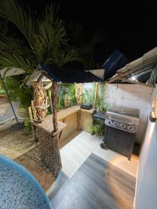 una cocina al aire libre con parrilla y sombrilla en Villa confortable para 7 personas, en Pedernales