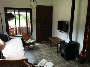 sala de estar con cama y TV en Hermosa casa con piscina climatizada entre el mar y las sierras en Bella Vista - Piriápolis, en Bella Vista
