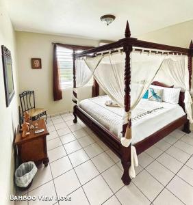 林康的住宿－Bamboo House- (electric generator) 8 min to beach，一间卧室配有一张天蓬床和一张桌子