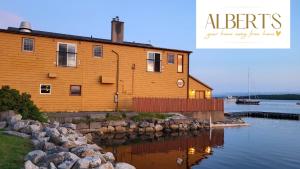 a large wooden house next to a body of water at Albert's in Shelburne