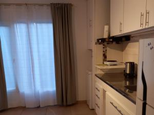 uma cozinha com um lavatório e uma janela com cortinas em -BLA BLA... em Ushuaia