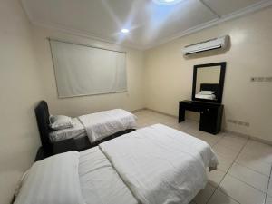 a hospital room with two beds and a mirror at Coov AlAnbarya in Al ‘Awālī