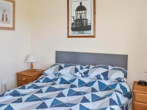 a bedroom with a blue and white comforter on a bed at Totland in Wootton Bridge
