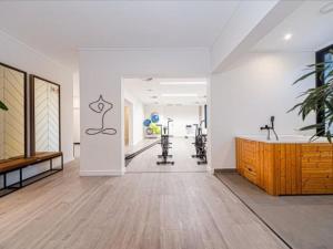 an empty room with a gym with treadmills and a wooden counter at Hyde Park Sandton Luxury 2BR Top Floor in Johannesburg