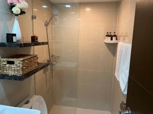 ein Bad mit einer Dusche und einem WC in der Unterkunft Viceroy Residences Chic Smart Home wifi Netflix in Manila