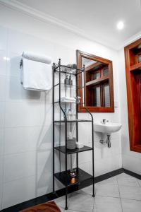 - une salle de bains avec une étagère noire à côté d'un lavabo dans l'établissement P5 Angkor Residence, à Siem Reap