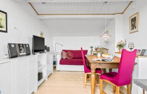 comedor con mesa y sillas rosas en 1 Bedroom Nice Home In Kirke Hyllinge, en Kirke-Hyllinge