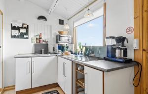 cocina con armarios blancos y encimera en 1 Bedroom Nice Home In Kirke Hyllinge, en Kirke-Hyllinge