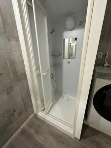 um chuveiro branco na casa de banho com uma cabina de duche em yokohama paradise101 em Yokohama
