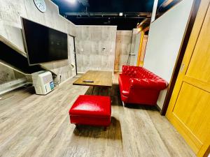 a room with a red couch and a table and a red stool at yokohama paradise101 in Yokohama