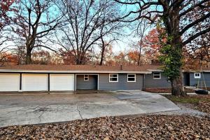 a house with a garage with a driveway at Entire Home w/ Free Wi-Fi, Garage, Deck, Yard in Nixa