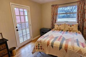 a bedroom with a bed and two windows at Entire Home w/ Free Wi-Fi, Garage, Deck, Yard in Nixa