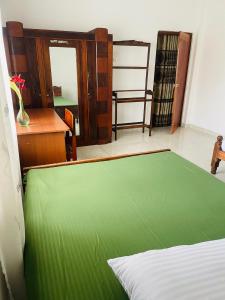 1 dormitorio con cama verde y escritorio en Thalalla resort, en Talalla South