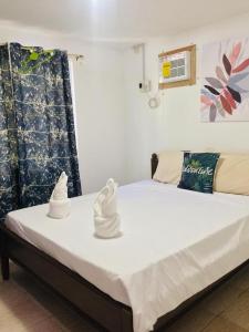 um quarto com uma cama com toalhas em Seashells Home em Panglao