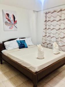 uma cama num quarto com duas almofadas em Seashells Home em Panglao