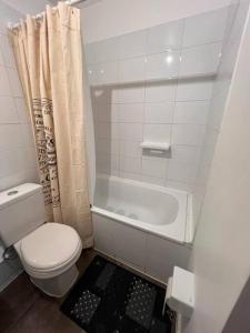 a bathroom with a toilet and a bath tub at Arriendo Depto Diario Alto Hacienda in Coquimbo