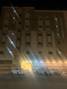 two cars parked in front of a building at night at Coov AlAnbarya in Al ‘Awālī