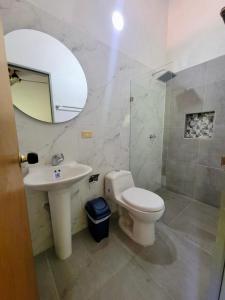 a bathroom with a toilet and a sink and a mirror at Finca Hacienda el Castillo Santa Fe de Antioquia in Santa Fe de Antioquia