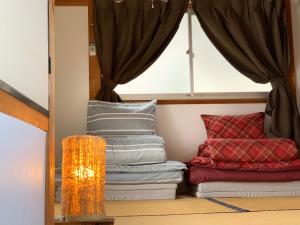 a room with a pile of pillows and a window at ヴィラ 奈良 with gift 小さなギフト付 奈良駅から15から20分 in Nara