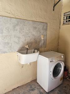 uma máquina de lavar roupa e um lavatório num quarto em Pringles Dpto Temporario 2 em Formosa