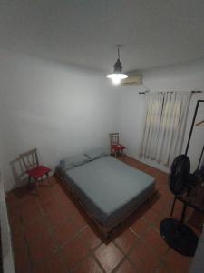 Un dormitorio con una cama y dos sillas. en Don José Cabañas, en Nogoyá