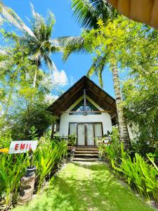 EPBliss Villas Resort Siargao في جنرال لونا: منزل أمامه أشجار نخيل