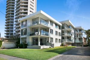 a large white apartment building with a lawn in front at Oceanfront 3-Bed with Beautiful Views in Burleigh in Gold Coast