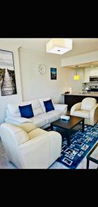 - un salon avec des canapés blancs et une table dans l'établissement Luxurious Downtown one bedroom Lake view apartment!!!, à Calgary