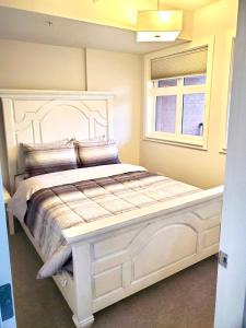 ein weißes Bett in einem Zimmer mit Fenster in der Unterkunft Luxurious Downtown one bedroom Lake view apartment!!! in Calgary