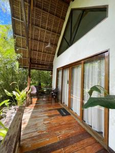 EPBliss Villas Resort Siargao في جنرال لونا: شرفة منزل مع شرفة خشبية