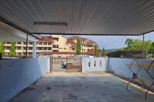 ein leerer Parkplatz mit einem Zaun und einem Gebäude in der Unterkunft Adno Homestay#3BR#2 Queen 1 Single 1 Sb#IKEA#High Speed Wifi#6pax in Simpang Ampat