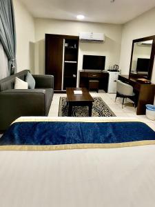 شقق عنوان المدينة للوحدات السكنية في المدينة المنورة: غرفة معيشة مع سرير كبير وأريكة