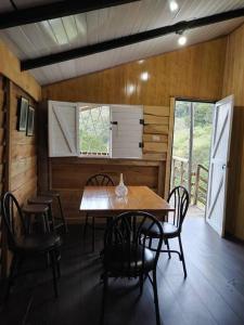 uma sala de jantar com uma mesa de madeira e cadeiras em Cabaña Rural de Montaña en La Cima de Dota 