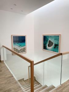 two paintings on a wall next to a staircase at Casa Z Paracas in Paracas