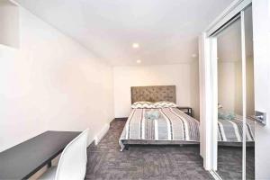 a white bedroom with a bed and a mirror at BEAU 4 CHAMBRES AU COEUR DU PLATEAU MONT-ROYAL in Montréal