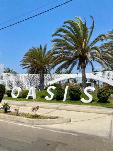 a large sign for a resort with palm trees at Casa Z Paracas in Paracas