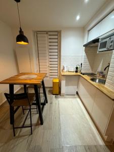 Appartement moderne au centre-ville في سان دوني: مطبخ صغير مع طاولة خشبية ومغسلة