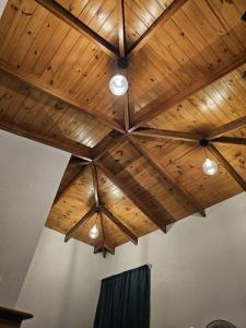 techo de madera con luces en una habitación en Cabaña acogedora cerca del río, en Naranjito