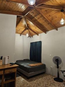 a bedroom with a bed and a wooden ceiling at Cabaña junto al río in Naranjito